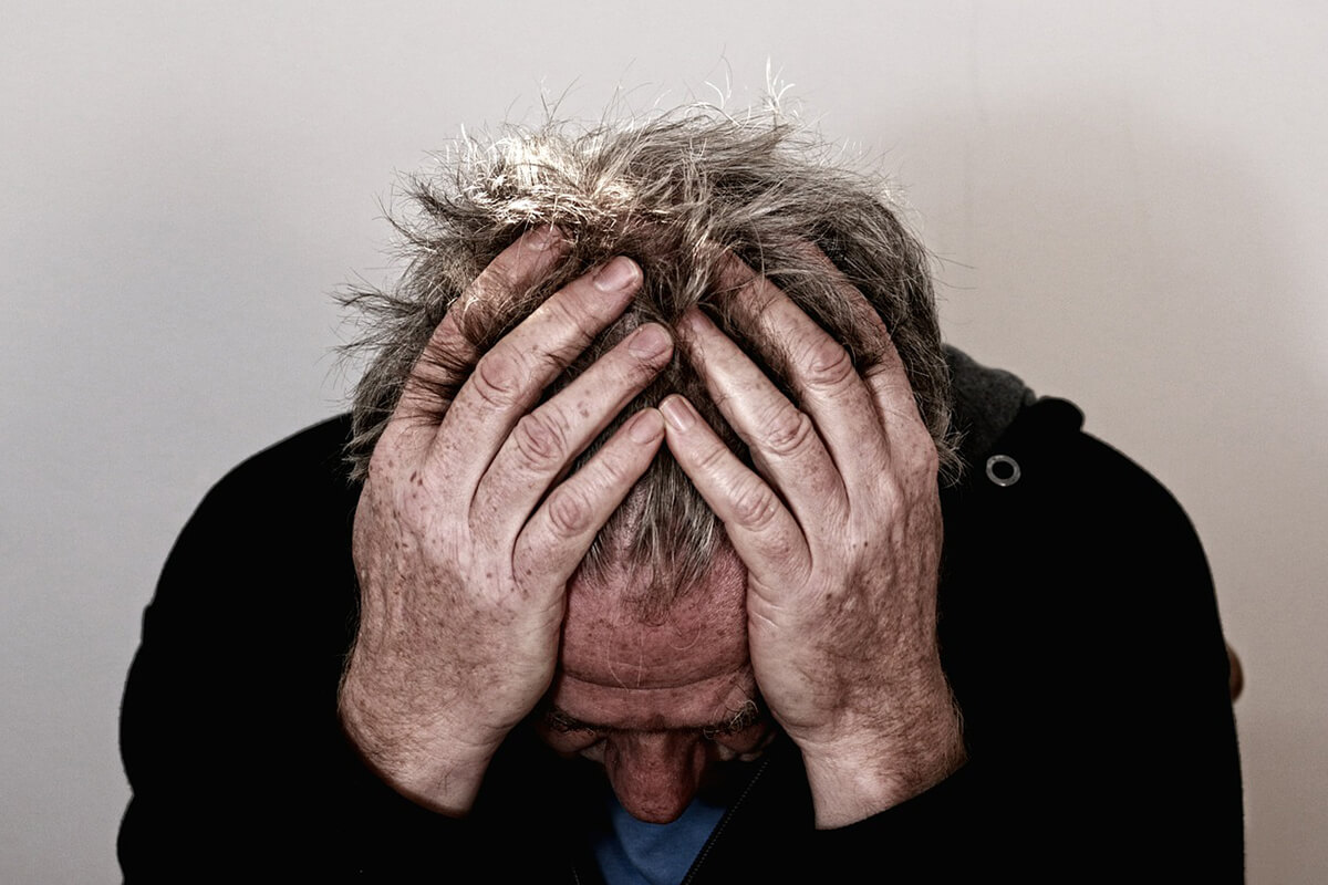 photo of man with head in his hands for free burnout assessment page on truby achievements website