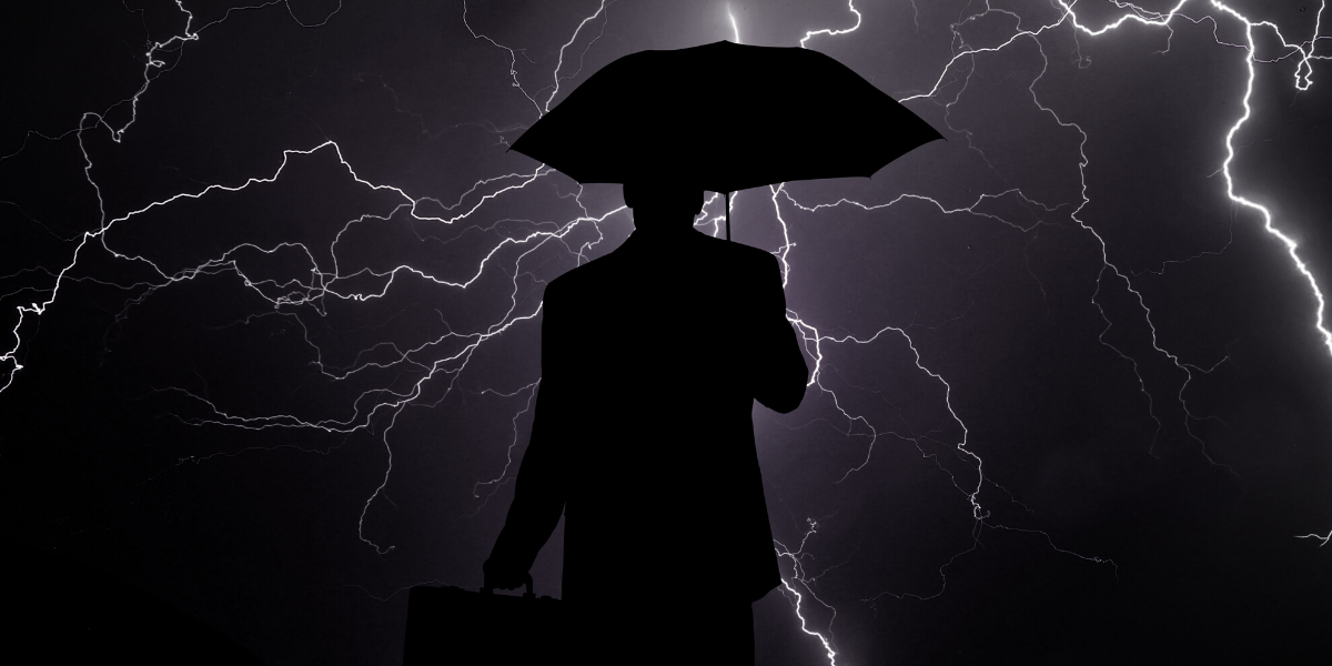 image of a man holding an umbrella in a lightning storm - for Truby Achievements blog post titled 10 tips for how to lead in a crisis