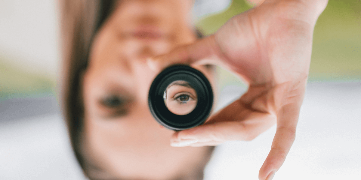 woman upside down looking through a lens showing right side up - featured image for perspective shift blog from truby achievements