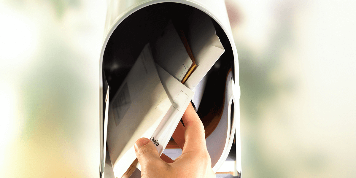 person reaching into mailbox to pull out letters - featured image for value through contribution blog article from truby achievements