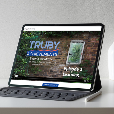 laptop on a silver table displaying the first lesson Episode 1 Learning - from Beyond the Mirror, Inner Transformation Course by Truby Achievements