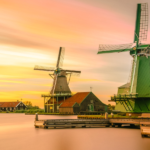 windmills along a water edge with a sunset in the back - featured image for dealing with difficulties blog by truby achievements