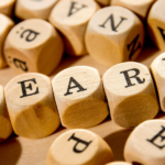 cubes with letters scatttered with "learn" visible - featured image for learning from everything achievement nudge blog by truby achievements